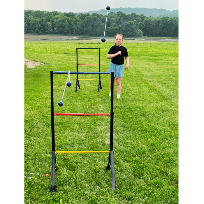 Person playing with a ladder ball game on a grassy field