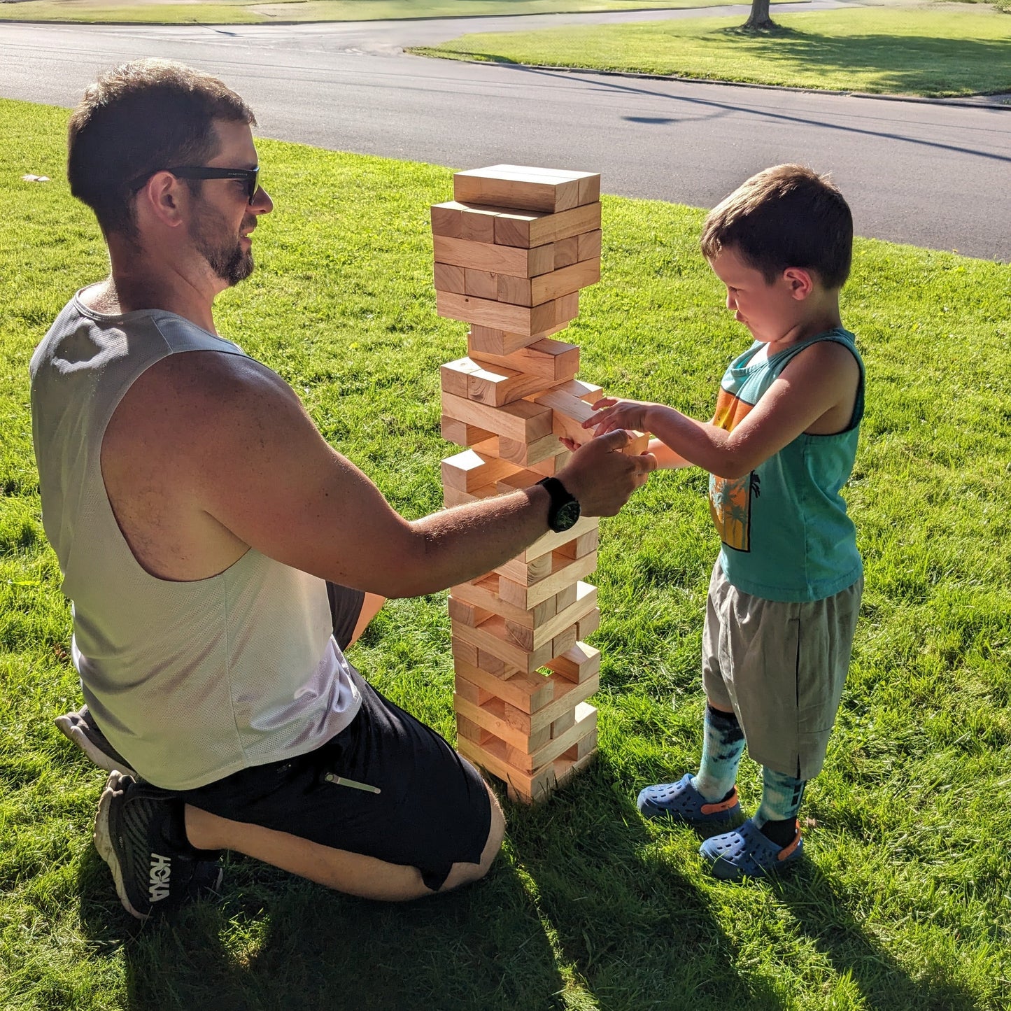 adult and child playing giant jenga outside