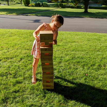 child playing giant outdoor jenga